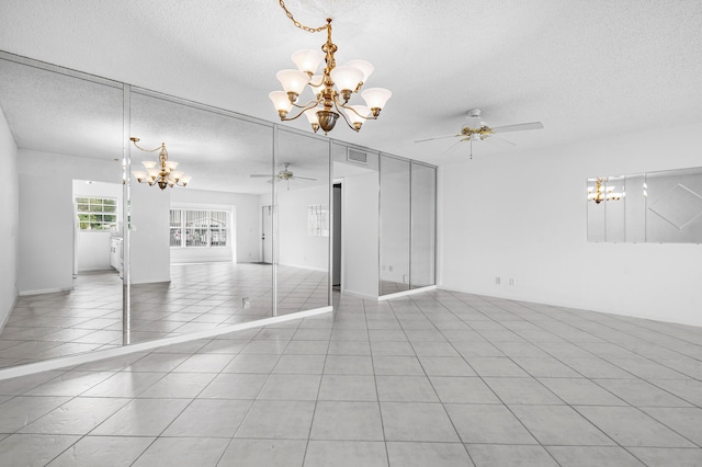 interior space with a textured ceiling and ceiling fan with notable chandelier