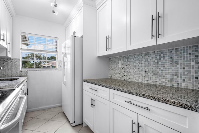 kitchen with stainless steel electric range oven, white refrigerator, backsplash, dark stone countertops, and white cabinets