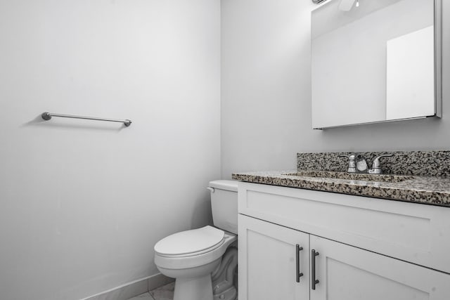 bathroom featuring tile patterned flooring, vanity, and toilet