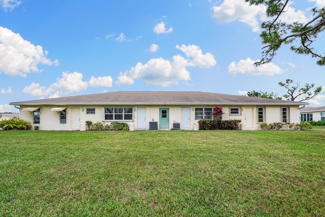 ranch-style house with central air condition unit and a front yard