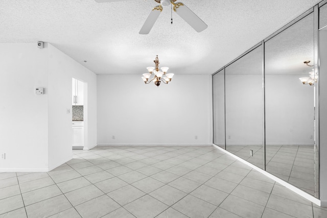 unfurnished room featuring ceiling fan with notable chandelier, a textured ceiling, and light tile patterned flooring