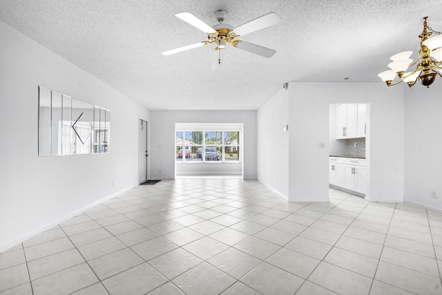 unfurnished living room featuring ceiling fan with notable chandelier, light tile patterned floors, and a textured ceiling