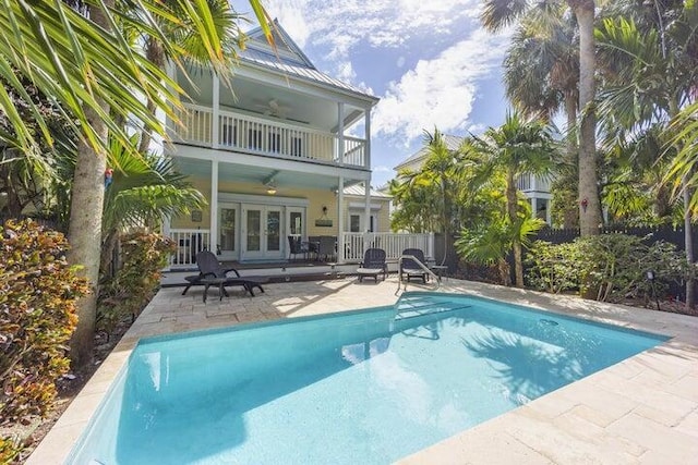 view of swimming pool with ceiling fan, a patio area, and french doors