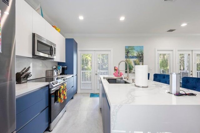 kitchen featuring a center island with sink, appliances with stainless steel finishes, french doors, white cabinets, and sink