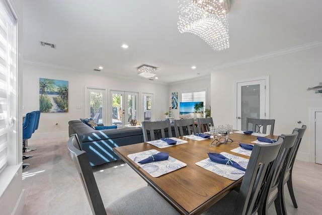 dining area with a chandelier, crown molding, and french doors