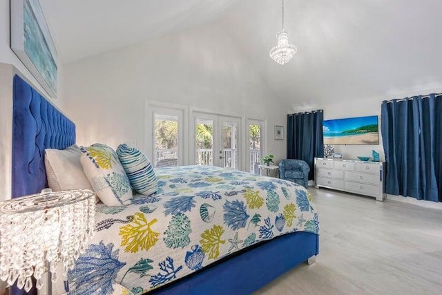 bedroom with high vaulted ceiling, french doors, and an inviting chandelier