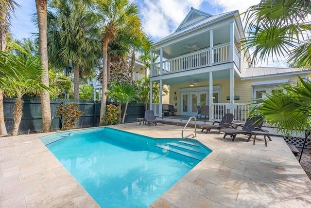 view of swimming pool with ceiling fan, french doors, and a patio