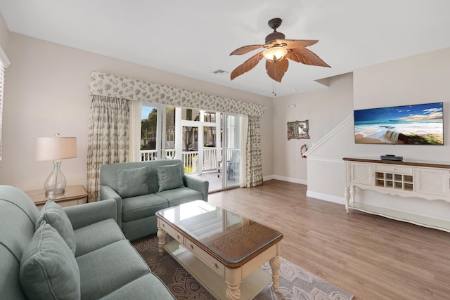 living room featuring ceiling fan and hardwood / wood-style flooring