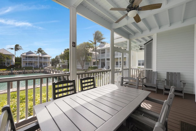 deck with ceiling fan and a water view