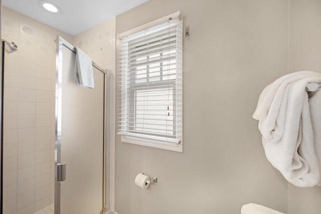 bathroom with a shower with door, a wealth of natural light, and toilet