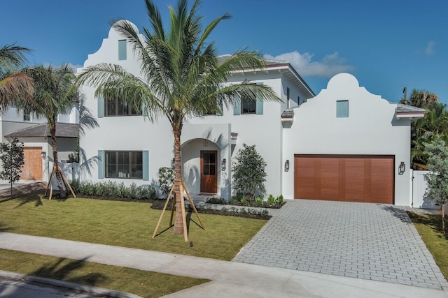 315 Avila Rd, West Palm Beach, FL 33405 - view of front facade featuring stucco siding, an attached garage, decorative driveway, and a front lawn