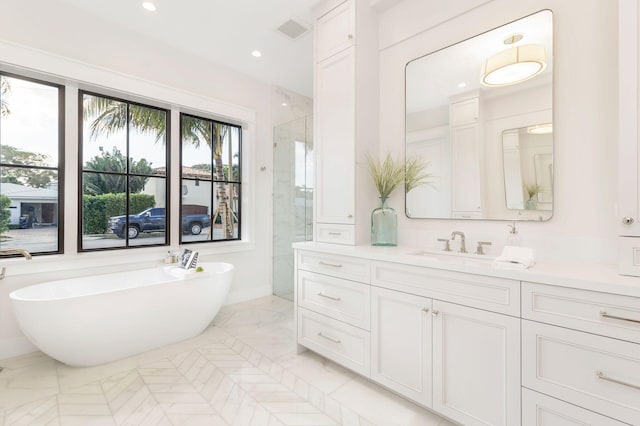 bathroom with vanity and shower with separate bathtub