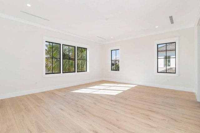 empty room with light hardwood / wood-style floors and crown molding