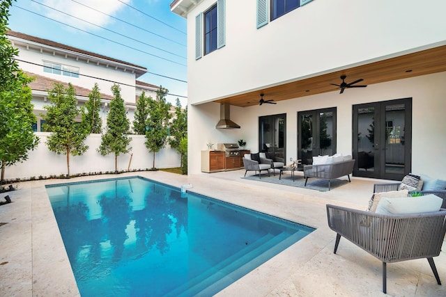 view of swimming pool with outdoor lounge area, ceiling fan, french doors, exterior kitchen, and a patio area