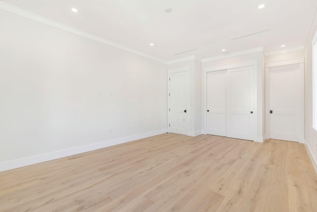 unfurnished bedroom featuring light hardwood / wood-style floors, crown molding, and a closet