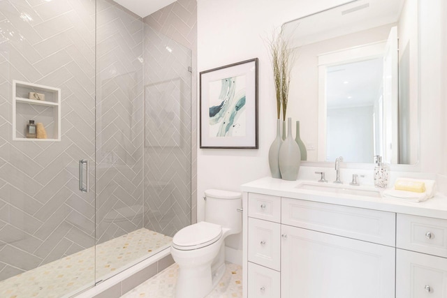 bathroom featuring vanity, a shower with shower door, and toilet