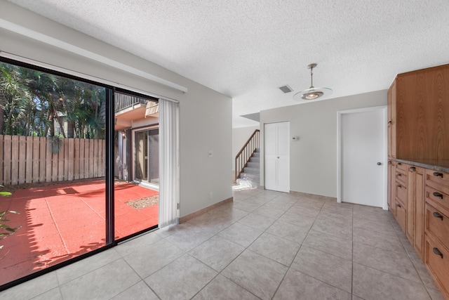 interior space featuring a textured ceiling and light tile patterned flooring