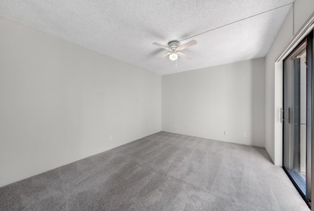 carpeted spare room with a textured ceiling and ceiling fan