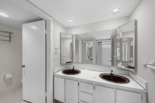 bathroom featuring vanity, toilet, and tile patterned flooring