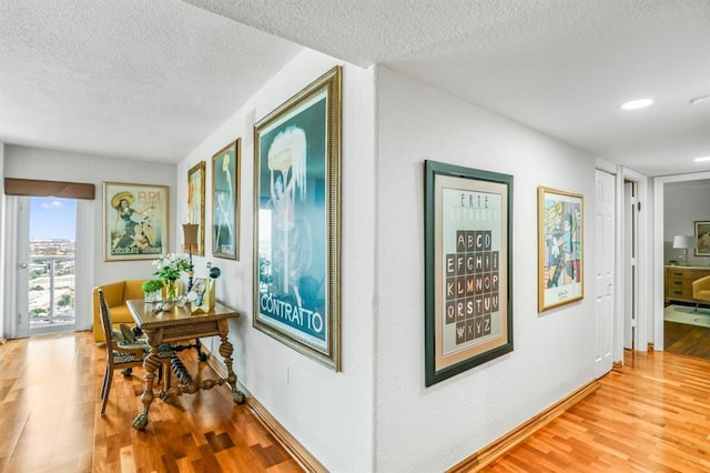 hallway with a textured ceiling and hardwood / wood-style flooring