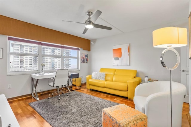 living room featuring ceiling fan and light hardwood / wood-style flooring