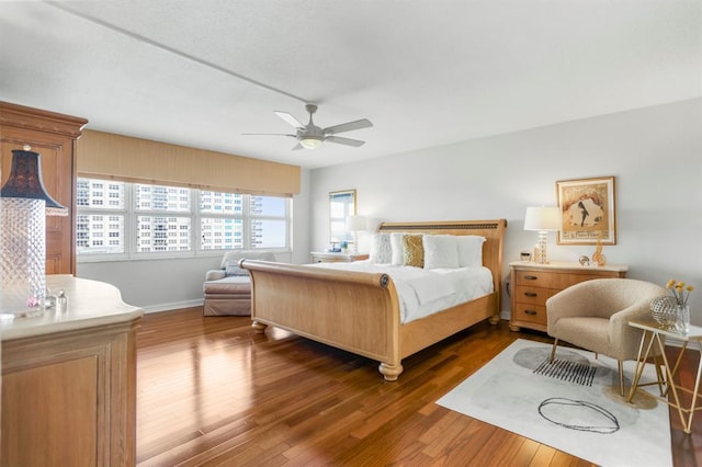 bedroom featuring multiple windows, dark wood-type flooring, and ceiling fan