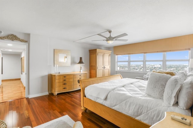 bedroom with ceiling fan and dark wood-type flooring