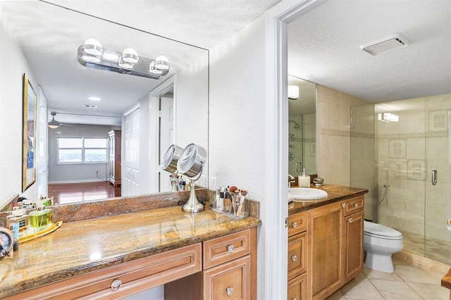 bathroom featuring ceiling fan, walk in shower, tile patterned flooring, a textured ceiling, and vanity