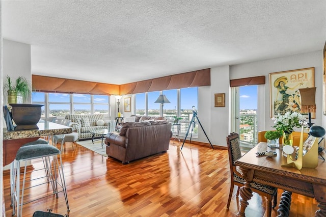 living room with a wealth of natural light, a textured ceiling, and hardwood / wood-style flooring