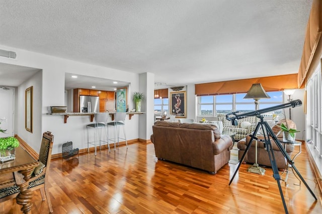 living room featuring a textured ceiling and light hardwood / wood-style flooring