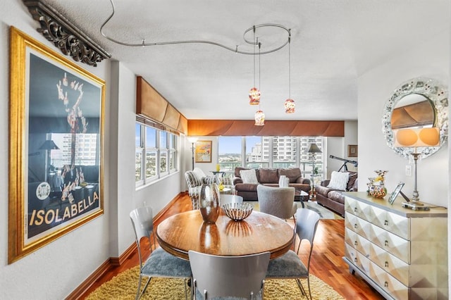 dining area with a textured ceiling, hardwood / wood-style flooring, and a healthy amount of sunlight