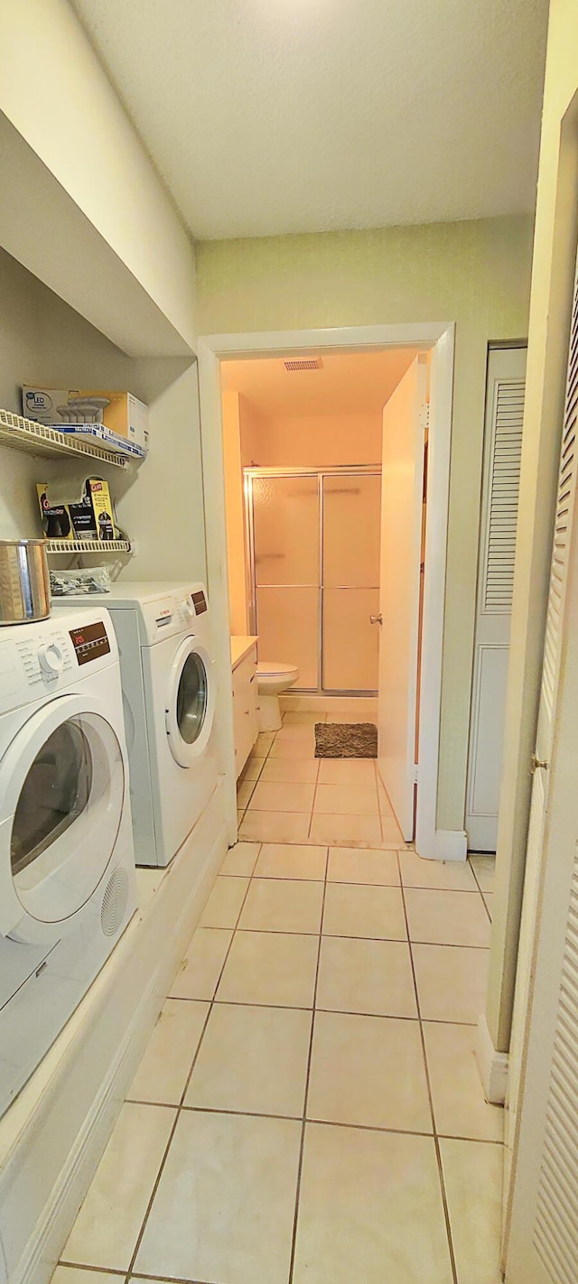 laundry room featuring light tile patterned floors and independent washer and dryer