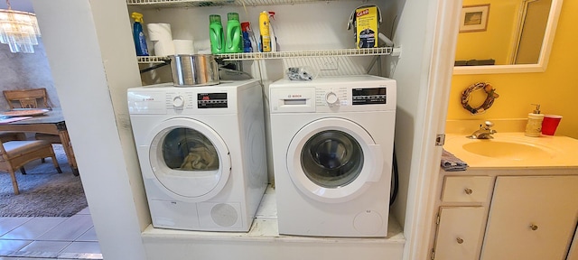 laundry room with tile patterned floors, independent washer and dryer, and sink