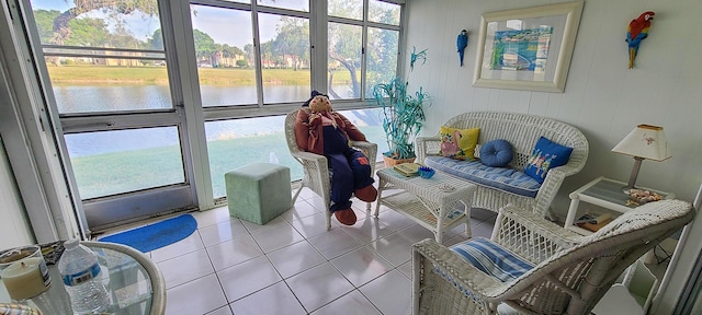 living room featuring a water view and light tile patterned flooring