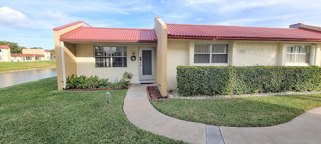 view of front of home featuring a front yard and a water view