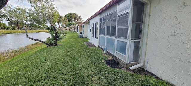 view of yard with central AC unit and a water view