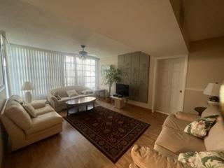 living room featuring hardwood / wood-style floors and ceiling fan