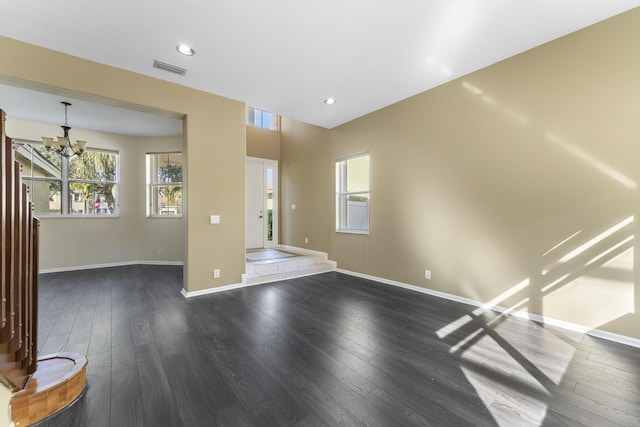 unfurnished living room featuring dark hardwood / wood-style floors and a chandelier