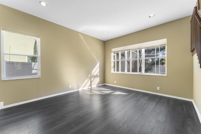 spare room featuring dark wood-type flooring and a healthy amount of sunlight