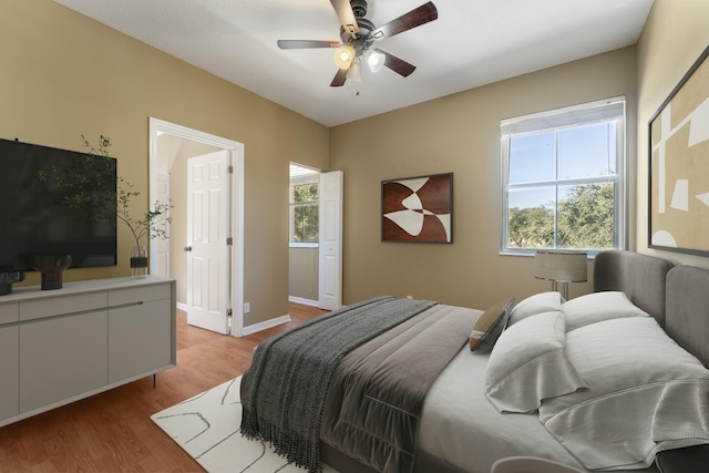 bedroom featuring light hardwood / wood-style floors, multiple windows, and ceiling fan