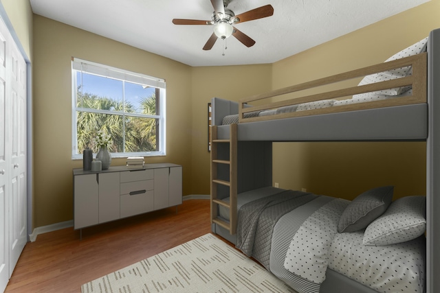 bedroom featuring ceiling fan, light hardwood / wood-style floors, and a closet