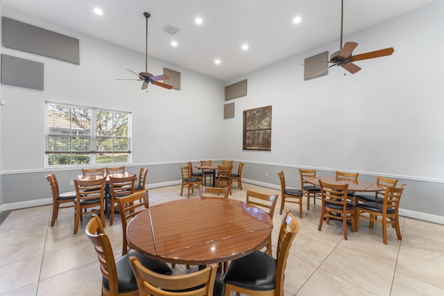 tiled dining space featuring ceiling fan and high vaulted ceiling