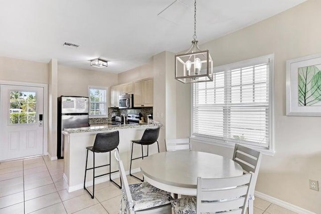 tiled dining space with an inviting chandelier