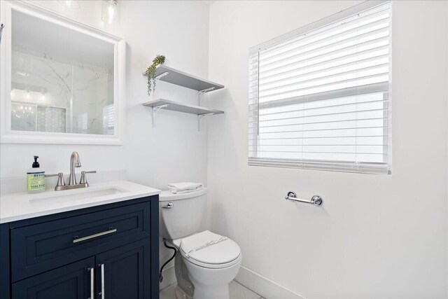 bathroom with vanity, toilet, and a wealth of natural light