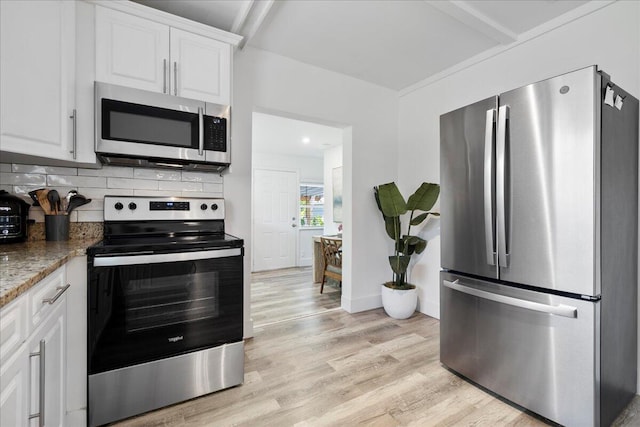 kitchen with backsplash, dark stone counters, stainless steel appliances, light hardwood / wood-style floors, and white cabinetry