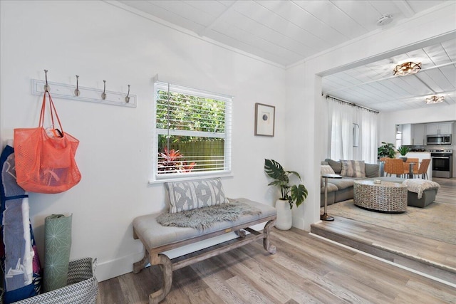 interior space featuring light wood-type flooring, ornamental molding, and wood ceiling