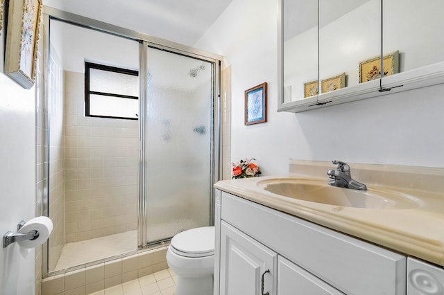 bathroom featuring tile patterned flooring, vanity, a shower with door, and toilet