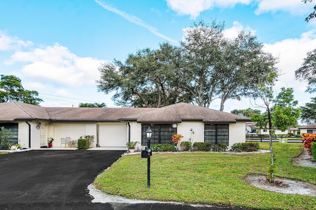 ranch-style home featuring a garage and a front lawn