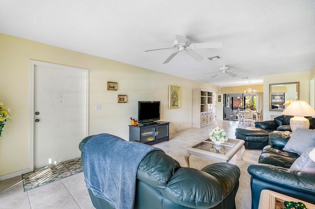 tiled living room featuring ceiling fan with notable chandelier and a textured ceiling