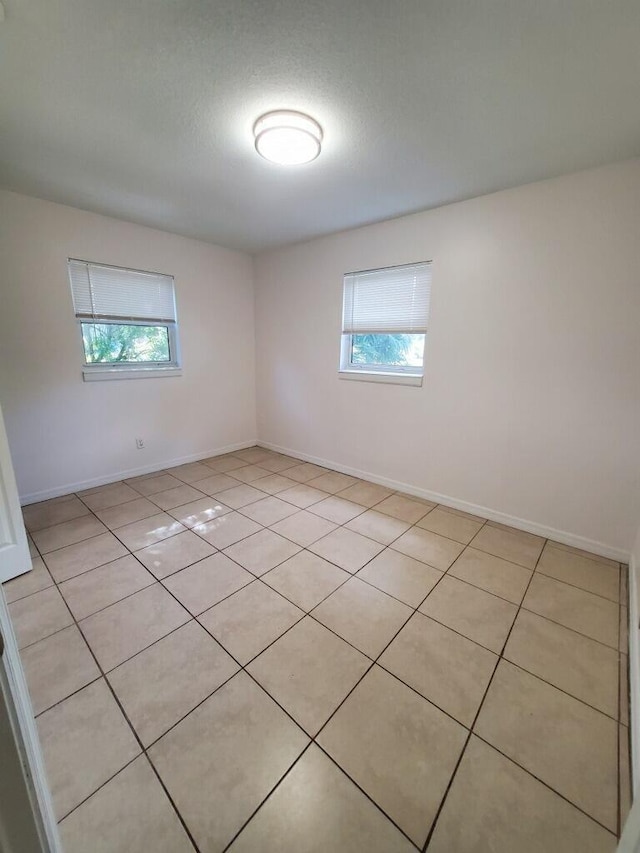 tiled empty room featuring a healthy amount of sunlight